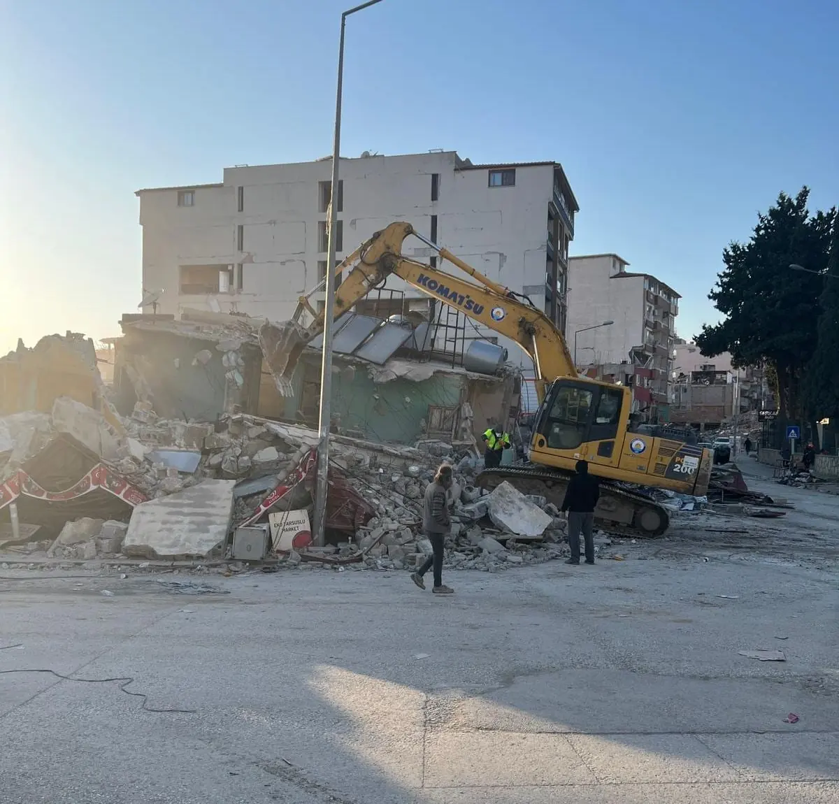 Excavator demolând o clădire afectată de cutremur