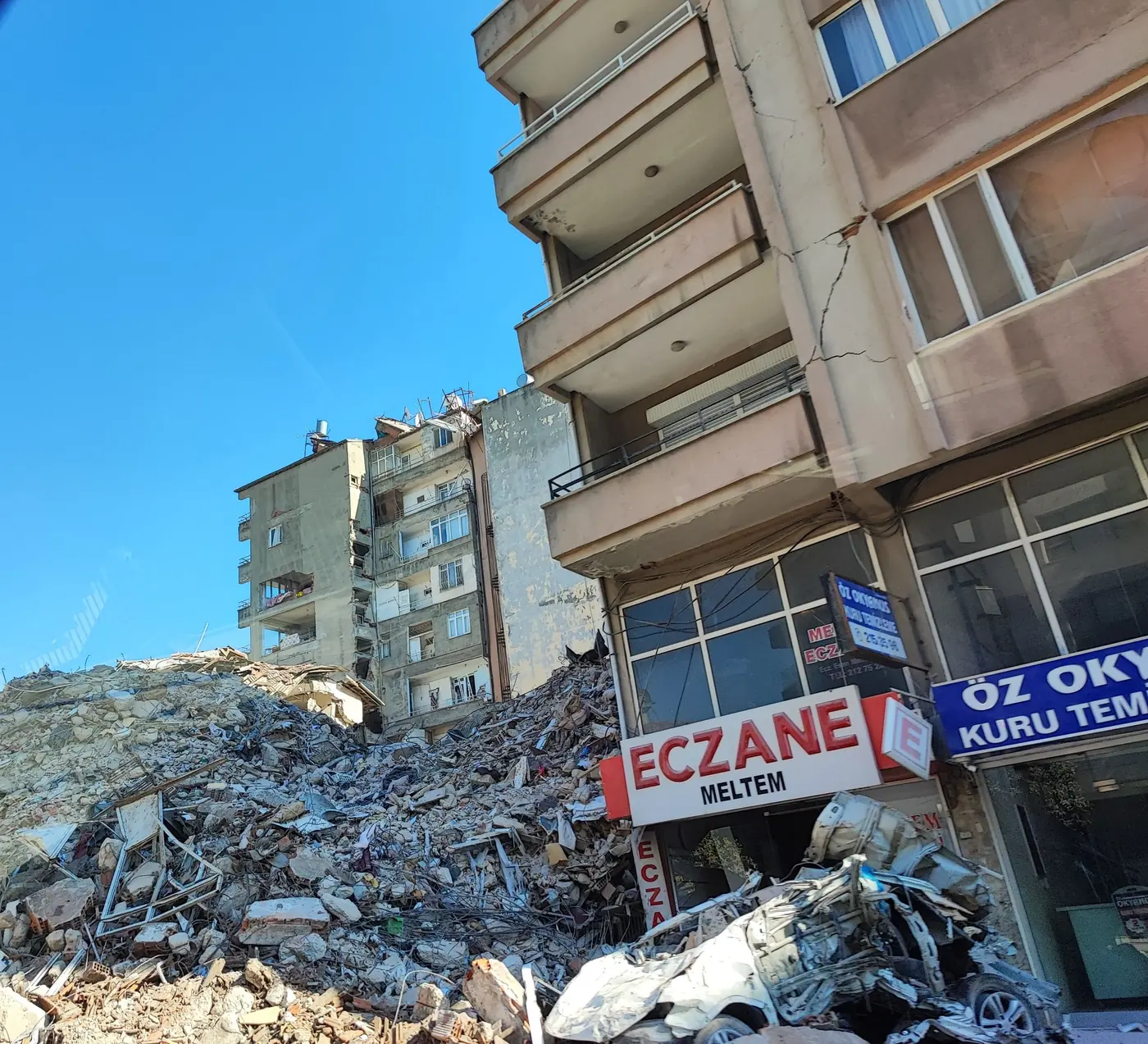 Dărâmături în fața unei clădiri cu o farmacie